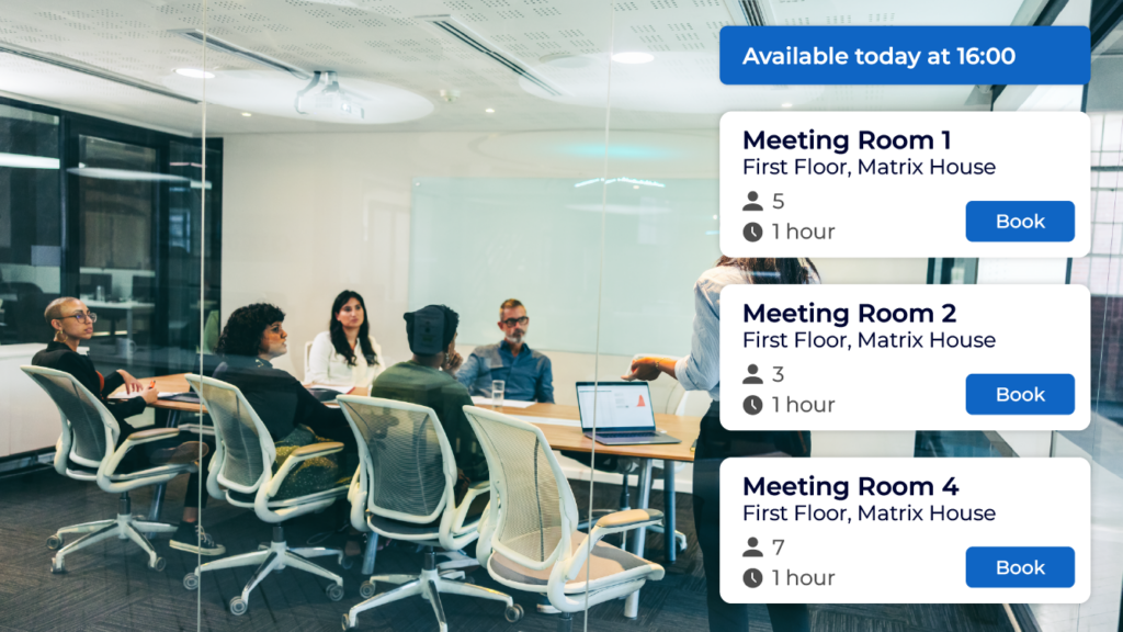 A meeting room within an office full of people. screen shows availability to book the meeting room. for that day using meeting rooms booking system.