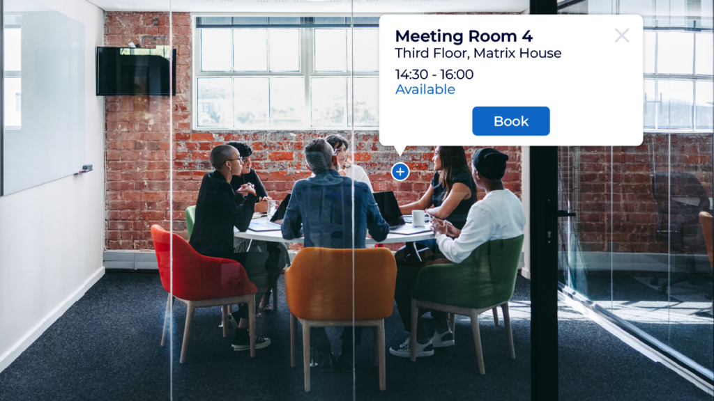 Meeting being held inside a meeting room within an office, Screen shows real-time meeting room booking availability to help employees find and book the right meeting room or workspace using Matrix Bookings' meeting rooms booking system.